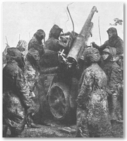 Camouflaged troops wearing gas masks, and manning an artillery piece.