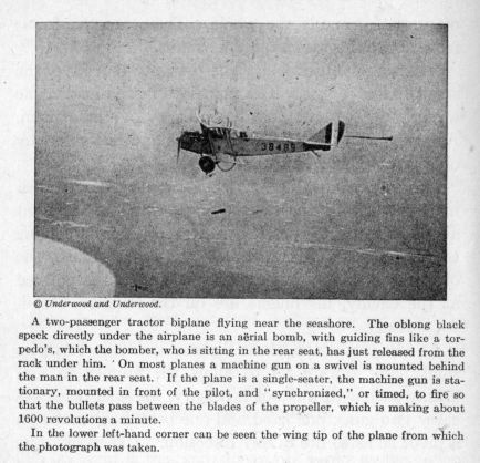 A two-passenger biplane flying near the seashore. The plane is shown dropping a bomb.